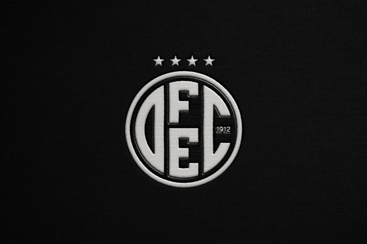 Detalhe do escudo bordado no tecido da camisa